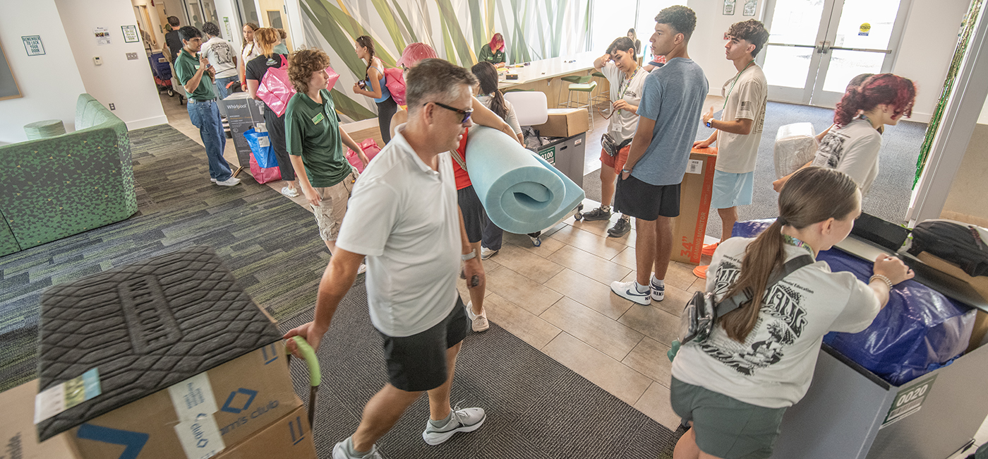 Parents and students hauling in dorm essentials during move in day at the new Living Learning Community.
