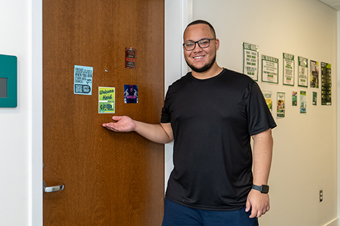 A Bellini College student stands outside his dorm in the new AI & Cyber LLC.
