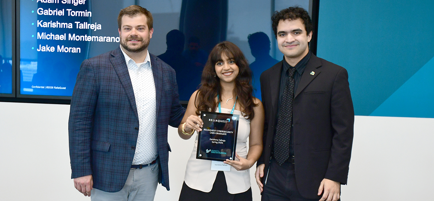 Karishma Tallreja is in the middle accepting an award at ReliaQuest.