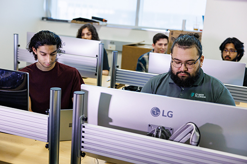Bellini Computing students sitting in front of computers.
