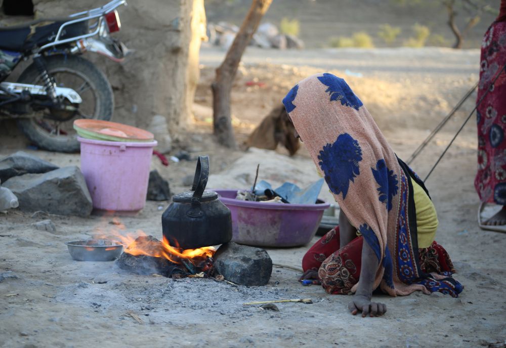 person sitting on the ground in front of firepit