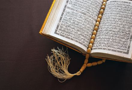 Religious text with mala beads marking a passage