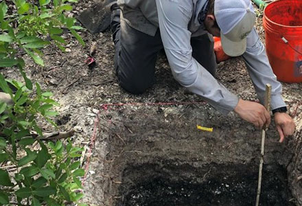 Rogers takes a depth measurement of a possible feature in a test unit. (Photo courtesy of Jaime Rogers)