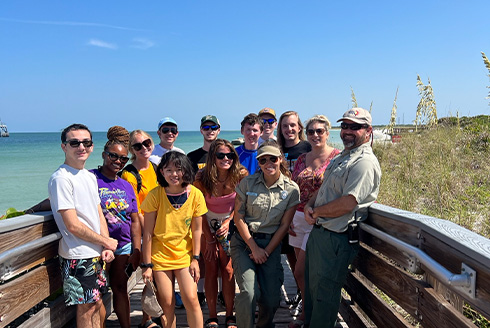 students standing on a beach boardwalk