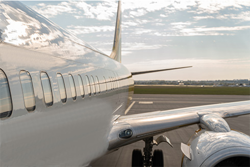 exterior side view of airliner sitting on a tarmac