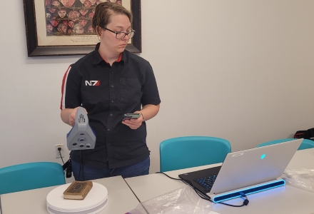 IDEx team member 3D digitizing via portable structure light 3D scanning a Talmud book from the 1940s. (Photo courtesy of Dr. Davide Tanasi)