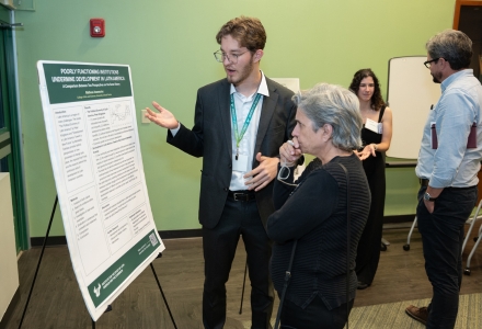 USF student Matheus Ivanesciuc of the USF Judy Genshaft Honors College shares his poster, “Poorly Functioning Institutions Undermine Development in Latin America: A Comparison Between Two Perspectives on the Same History,” during the student poster session of the symposium. (Photo by Corey Lepak)