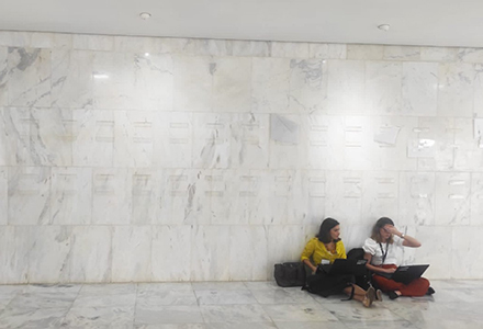 Brazilian journalist, Lorenna Rodrigues (left) sitting with a colleague (right) on the floor of the Palacio de Planalto (Brazil’s Presidential Palace). The pair were working on a story following the 2023 Brazil Congress Attack. (Photo courtesy of Lorenna Rodrigues)