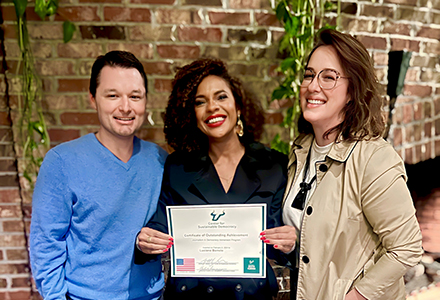 Brazilian journalist, Luciana Barreto (middle) and Dr. Joshua Scacco (left), posing with her program completion certificate. (Photo courtesy of Luciana Barreto)