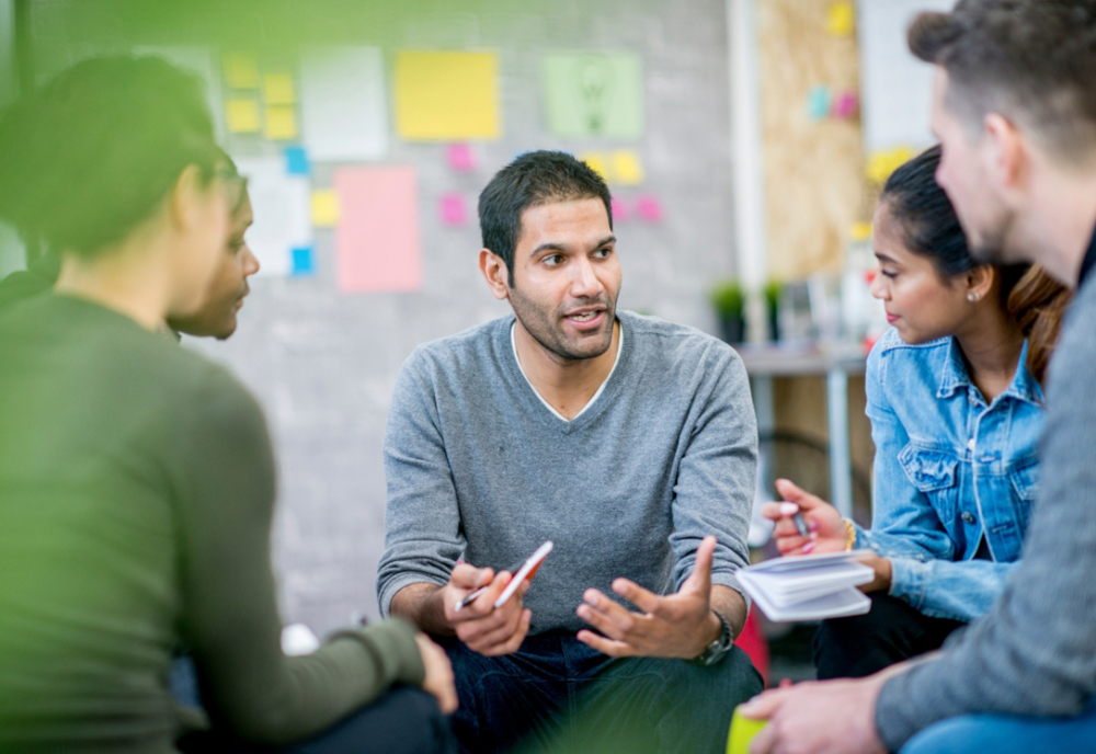 man talks with team members