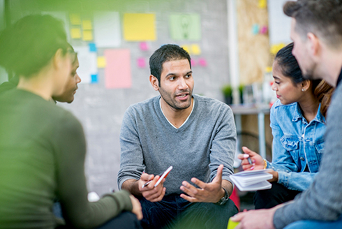 man talks with team members