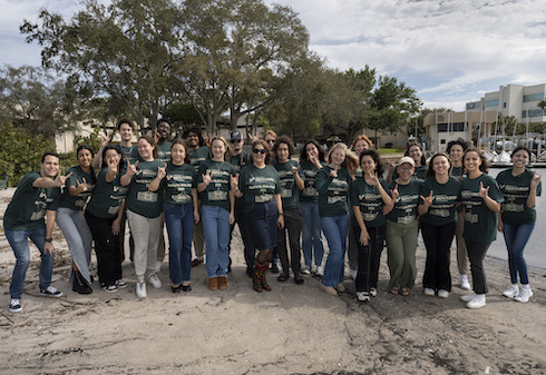 Group of students wearing matching green t-shirts