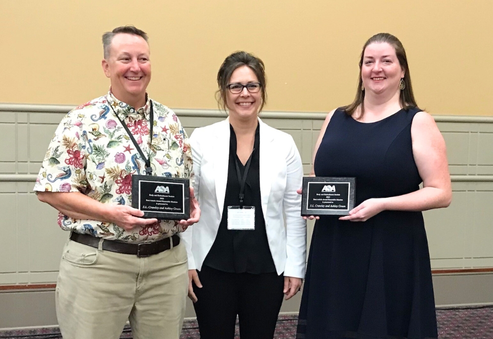 (From left) Dr. S.L. Crawley and Dr. Ashley Green (right), accepting their award from the American Sociology Association for their work featured in The Oxford Handbook of Symbolic Interaction. (Photo courtesy of Dr. S.L. Crawley)