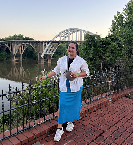Ariadna Ruiz Islas stands at a fence in front of the Edmund Pettus Bridge.