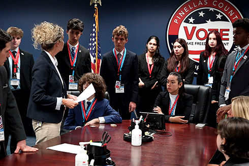students gathered around boardroom table in front of Pinellas County Vote sign