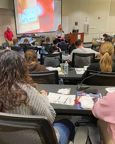 Students watch sutchering demonstrations and follow along with Barry University podiatrists. (Photo by Alessandra Silva-Casanova)