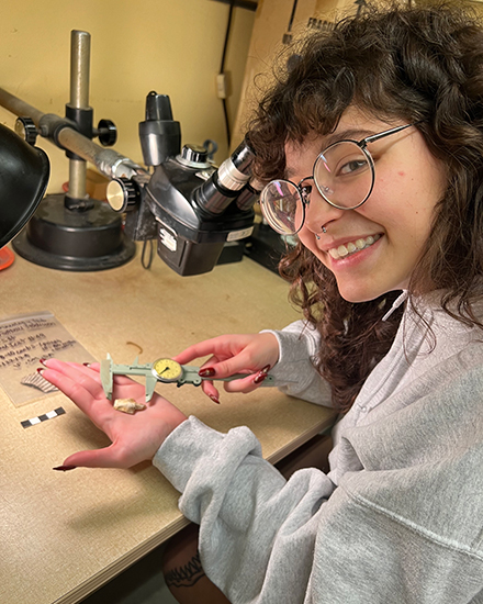 Sofia Arias, undergraduate anthropology student, measuring an arrowhead found from surveying the location of USF’s future football field. (Photo courtesy of Sofia Arias)