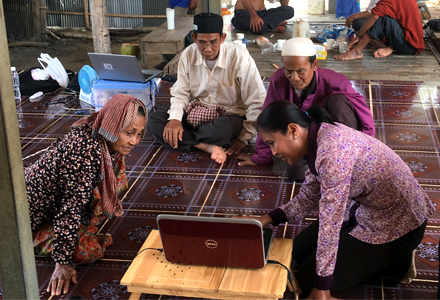 Local NGO workers provide mental health training resources to rural populations using laptops. (Photo courtesy of Elena Lesley)
