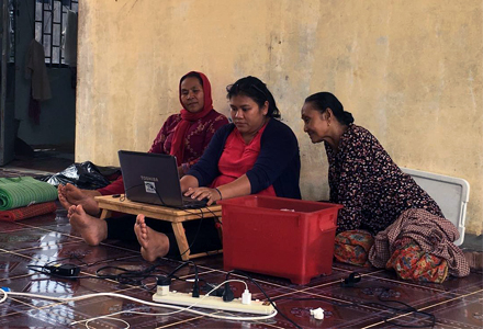 Local NGO workers provide mental health training resources to rural populations using laptops. (Photo courtesy of Elena Lesley)