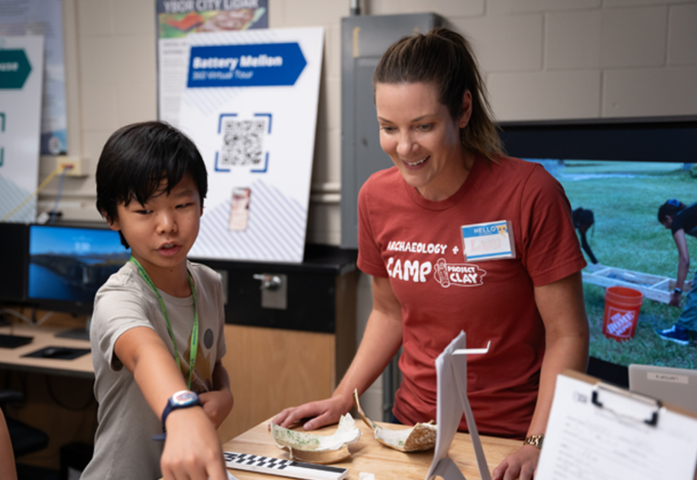 Harrison (right) working with students on displaying reconstructed finds from their archaeological excavation for the Gallery Show at the end of the week. Photo credit: Corey Lepak. 