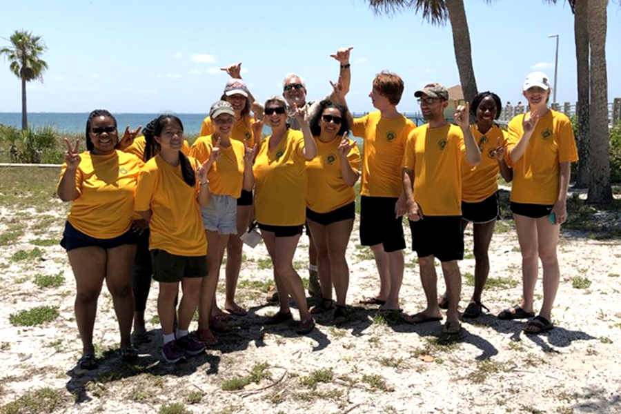 group of students in yellow shirts on a beach