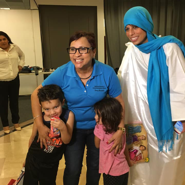 Nancy Hernandez, Dr. Alessandra Rosa, and two kids from the event pose to take a photo after opening their gifts.