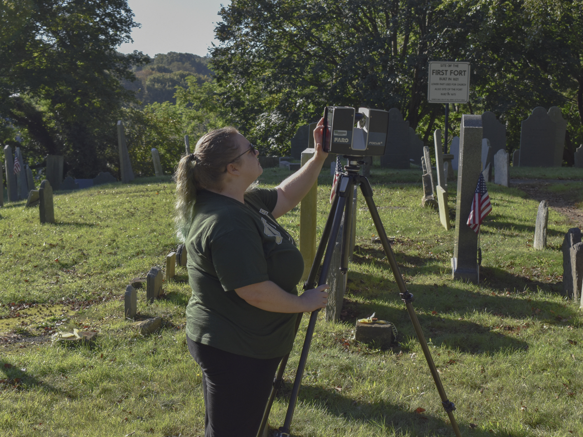 student works with camera in cemetery