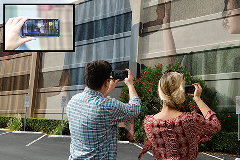man and woman viewing a building with cell phones