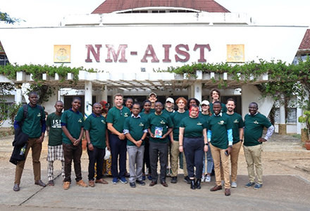 Research team standing in front of NM-AIST building