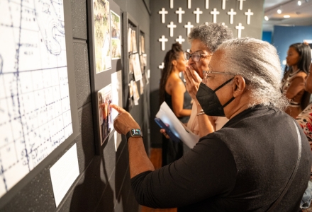 Exhibit attendees recognize some of their ancestors in photographs throughout the exhibit. (Photo by Corey Lepak)