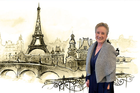 Jody McBrien in front of an illustration of Paris and the Eiffel Tower