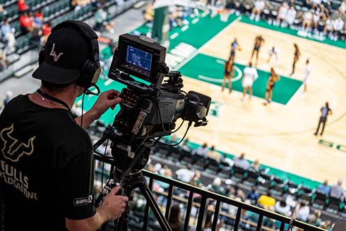 camera person wearing Bulls gear films basketball game