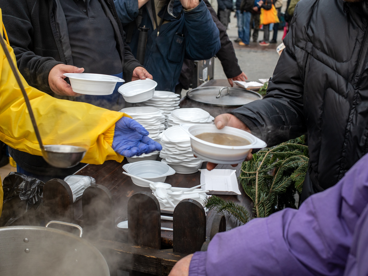 people receiving bowls of soup