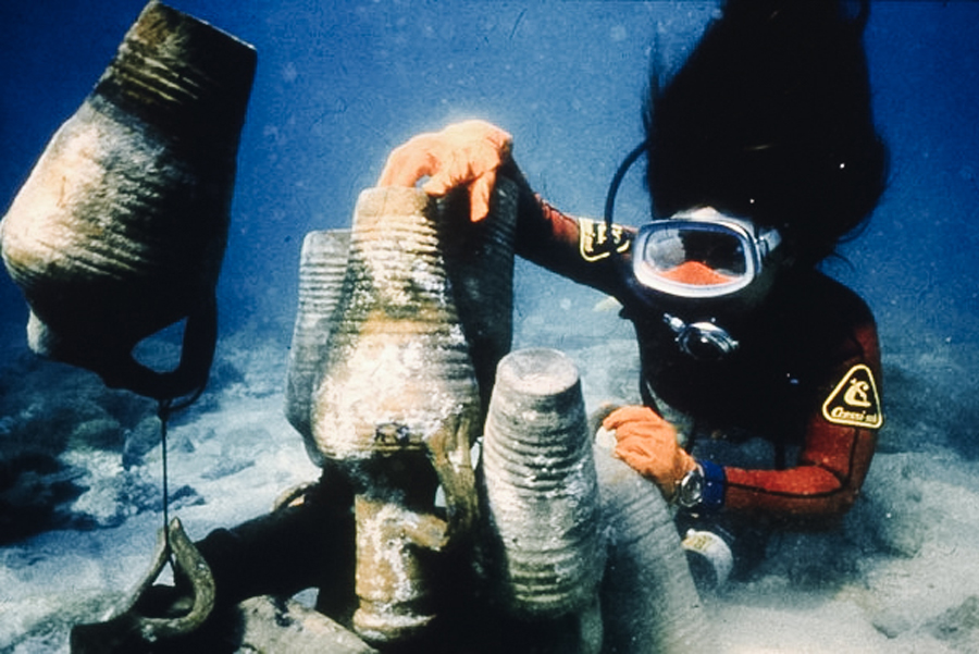 Scuba diver looking at sunken pottery