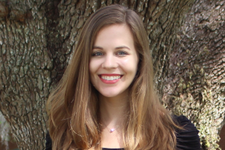 Headshot of Katie Walkup smiling into the camera in front of a tree