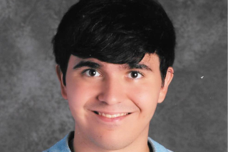 Portrait of Richard (Rick) Reisinger smiling at the camera with a grey studio background