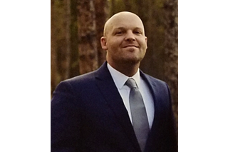 Headshot of Adam Carter smiling into the camera