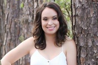 Picture of Nicole Musselman smiling into the camera and standing in front of a tree