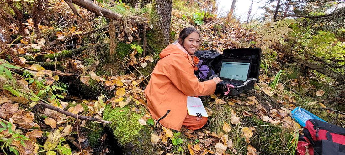 Tyelyn on a wooded hillside setting up a thermistor.