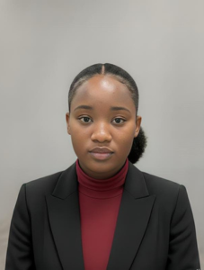 headshot of a woman wearing a red turtle neck shirt under a black suit jacket against a black background with a neutral face