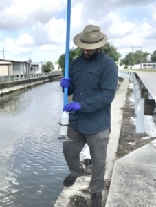 person wearing straw hat wearing gloves holding tool near water