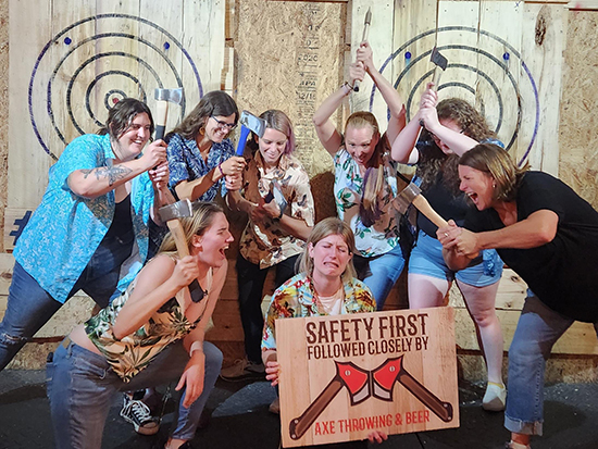 group holding axes at ax throwing venue