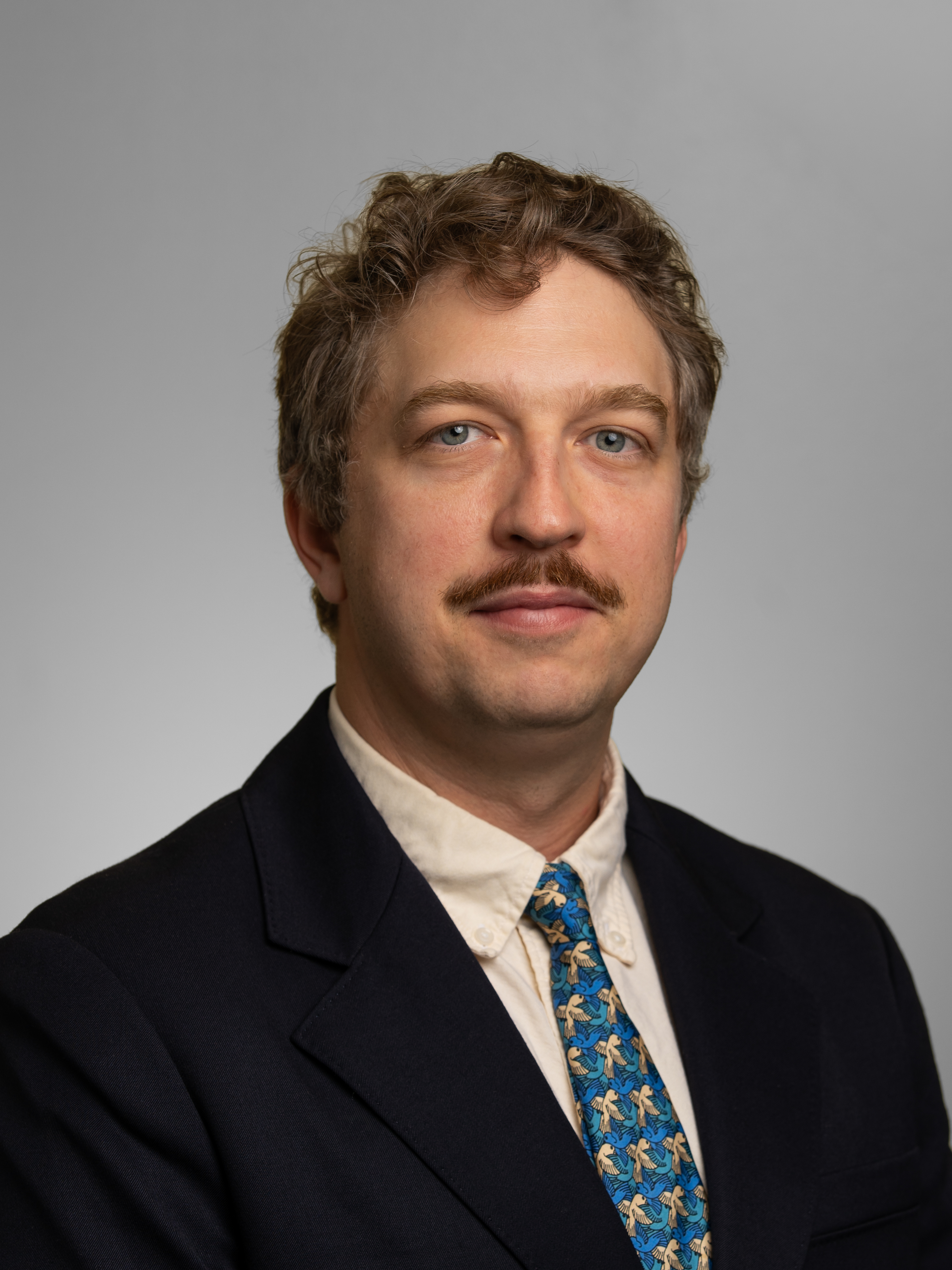 Man in navy blue jacket and gray-blue shirt