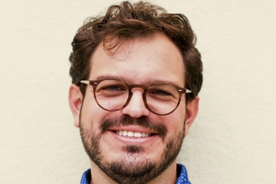 Picture of Anthony Vincent. A man facing the camera with a short beard and round glasses.