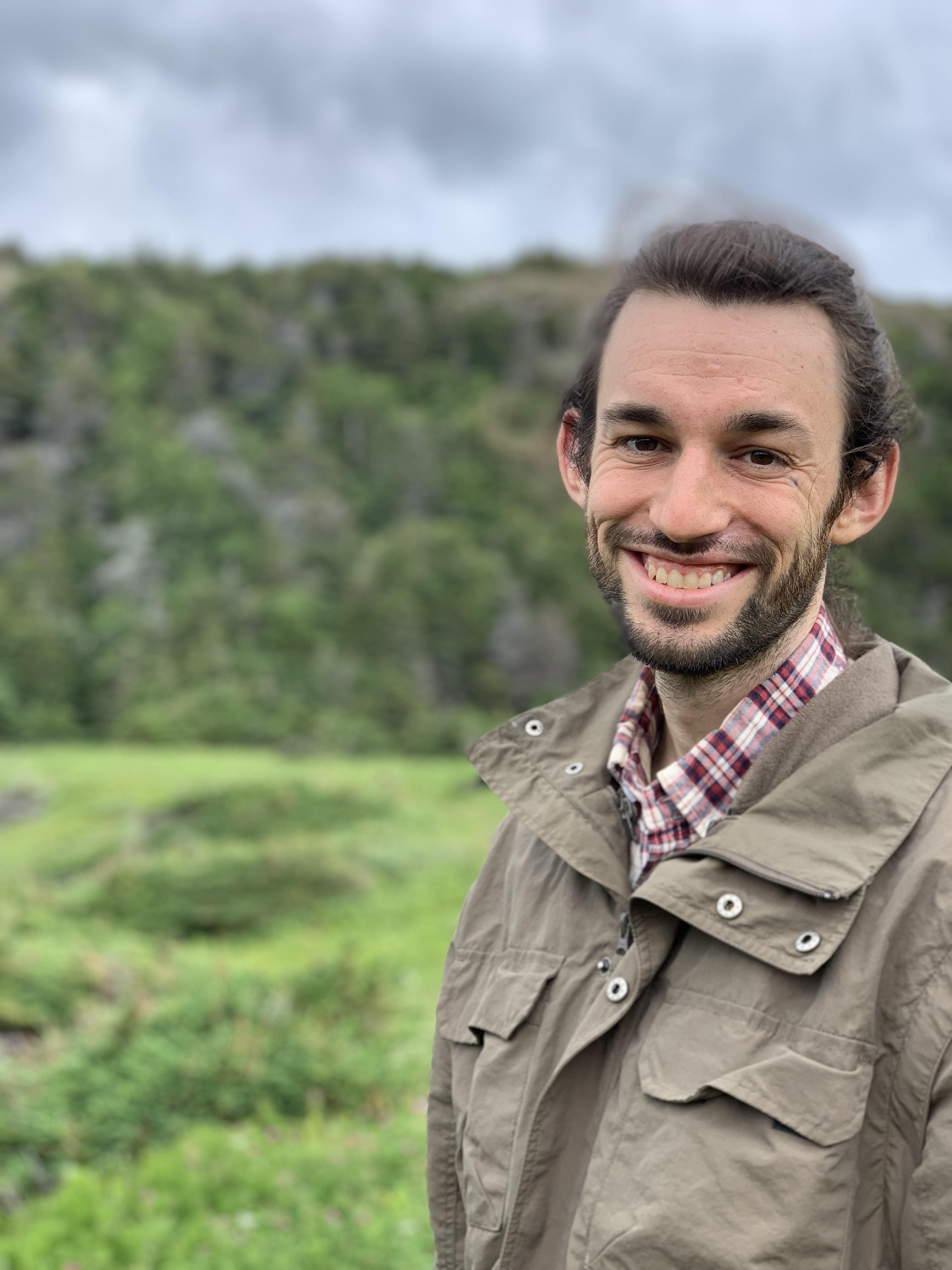 Picture of man smiling with scenic green backdrop