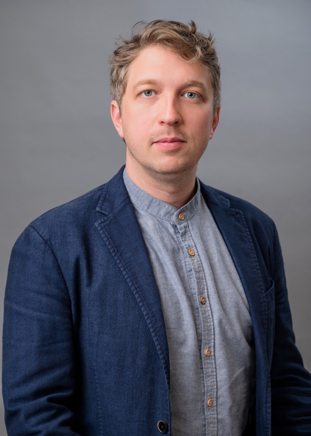 Man in navy blue jacket and gray-blue shirt