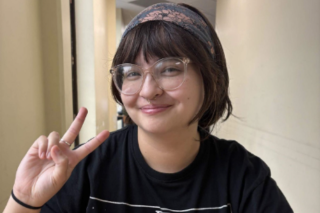 Georgia smiling and holding up a peace sign