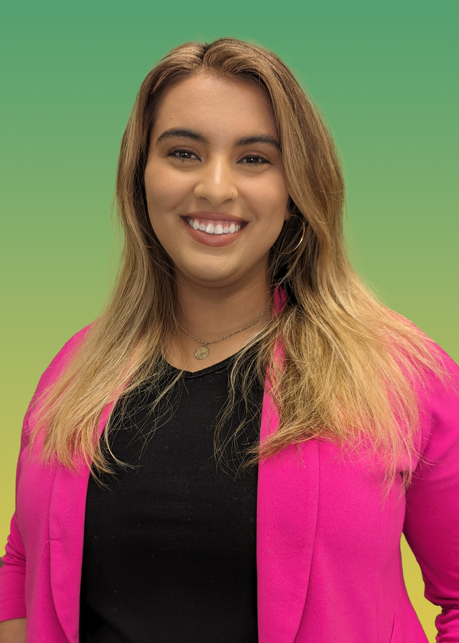 Portrait of Christina Yelvington wearing a black blouse and bright pink suit jacket.