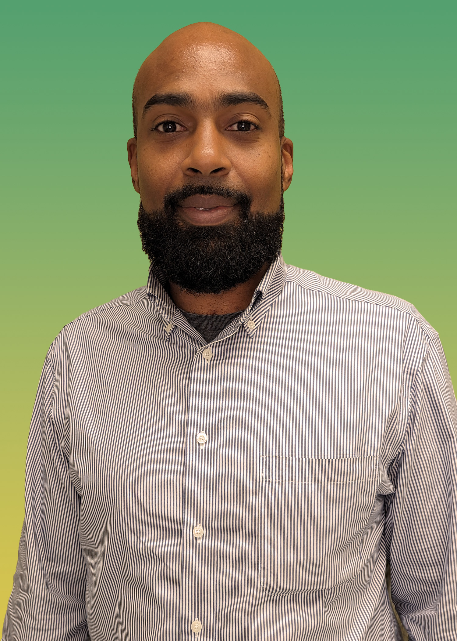 Portrait of Kareem Rhodd wearing a stripped button down, long-sleeve shirt. 