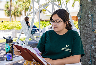 student reading book outdoors